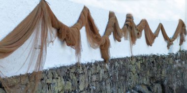 Balıkçının evinin duvarında asılı balık ağları