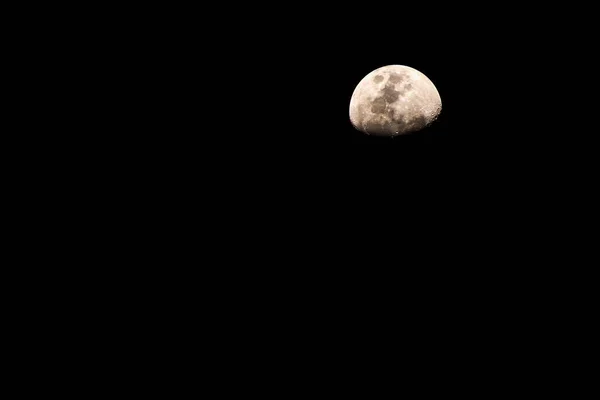 Moon. Half Moon Shrouded in Darkness on Black background