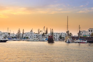 Tunus, Port El Kantaoui 'deki inanılmaz marina, mavi ve altın rengi gökyüzü, denizde yansımalar ve güzel yatlar, beyaz villalar ve oteller.