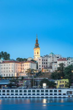 Önünde Sava nehri, arkasında baş melek Michael katedrali ve limanda etkileyici, büyük bir kruvazör gemisi ile Belgrad 'ın mavi saat manzarası.
