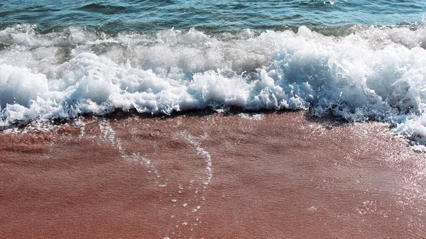 Schuimige Zeegolf Rood Zand Waterplons Waterdruppels Het Strand Van Aretes — Stockfoto