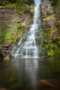 Sırbistan 'daki Eski Dağ' da (Stara Planina) manzaralı Tri kladenca şelalesi, suda yansıma ve ıslak kayalarda canlı yeşil bitkiler