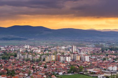 Pirot şehrinin üzerindeki inanılmaz mavi saat gökyüzü şehir ışıkları ve sisli ufuk dağlarıyla aydınlanıyor.