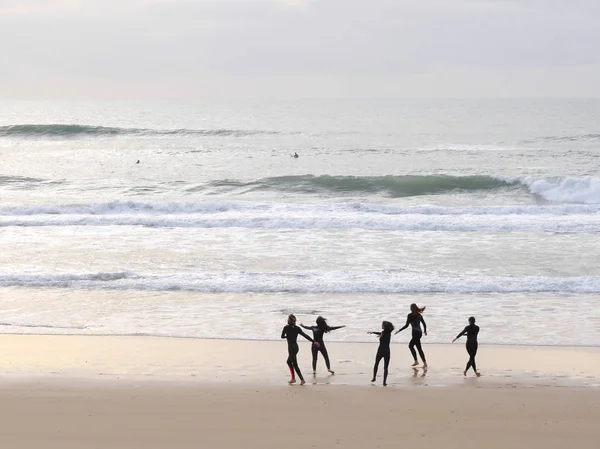 Surfeurs qui transportent des planches de surf sur une plage océanique — Photo