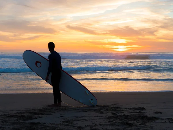 Surfeurs qui transportent des planches de surf sur une plage océanique — Photo