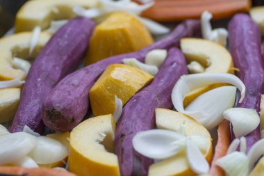 Renkli kök sebze karışımı: havuç, sarı kabak, mor tatlı patates, soğan ve sarımsak.. 