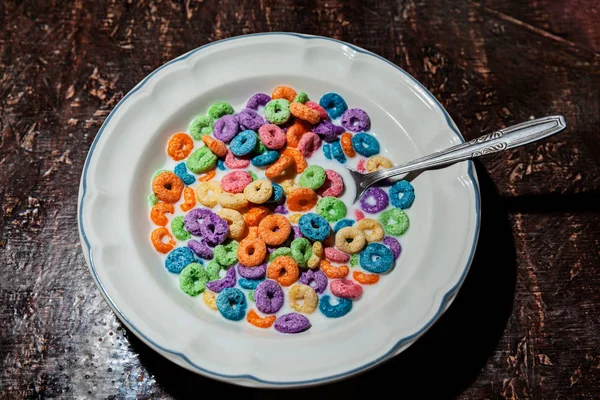 White plate of colorful fruit cereal loops with milk, morning br — Stock Photo, Image