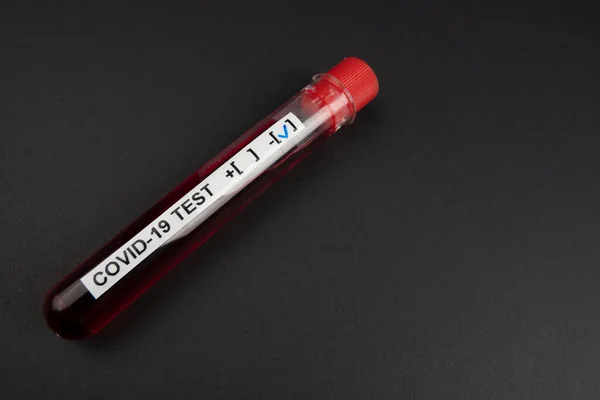 Corona virus blood test concept: A test tube with NEGATIVE COVID-19 result on black background with copy space