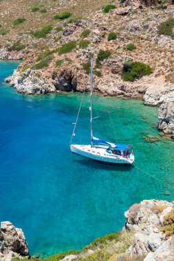 Güzel mavi sularda demirli yelkenli tekne - dikey