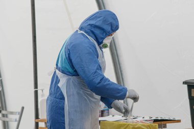 Korumalı kostümlü sağlık görevlileri Coronavirus testi yapıyor. Covid-19 roman salgını
