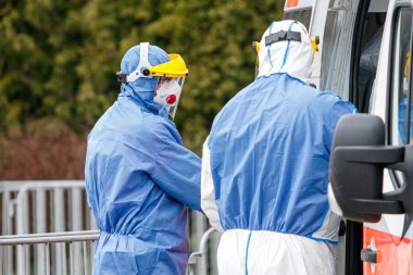 Korumalı kostümlü sağlık görevlileri Coronavirus testi yapıyor. Covid-19 roman salgını