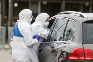 Korumalı kostümlü sağlık görevlileri Coronavirus testi yapıyor. Covid-19 roman salgını