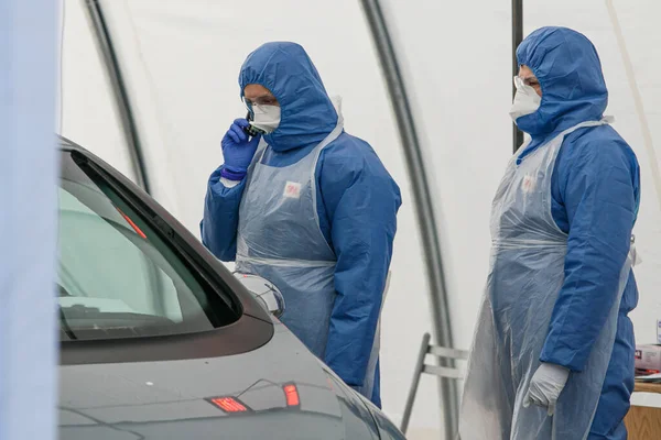 Coronavirus kontrol noktası. Korumalı kostümlü sağlık görevlileri koronavirüs için kan örnekleri alırlar (Covid-19)