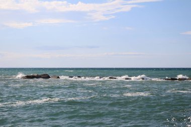 Deniz manzarası Bari rıhtımından çekilmiş, su küçük dalgalar ve köpükle birlikte.