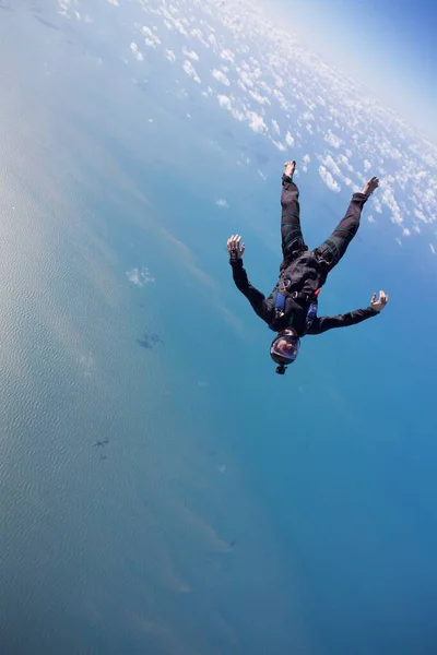skydiver in free fall over brazilian beach