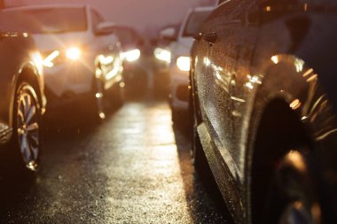 Yağmurlu bir gecede trafik sıkışık. Sıra sıra arabalar.