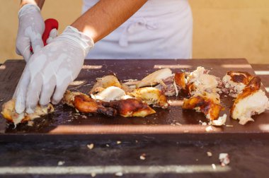 Şefin eli ızgara tavuğu keser.
