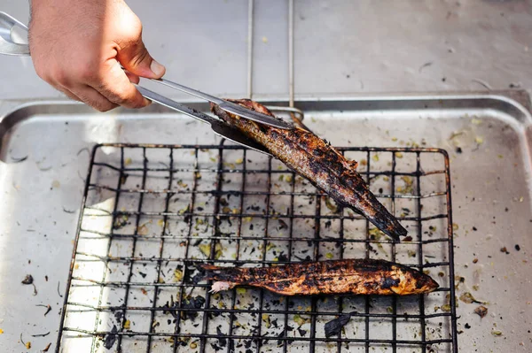 Master chief is grilling fish at open kitchen