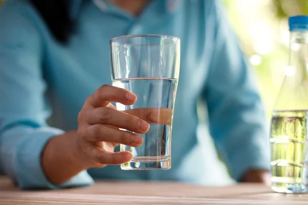 Mujer Sosteniendo Vaso Agua Potable Sobre Una Mesa Madera Fondo — Foto de Stock