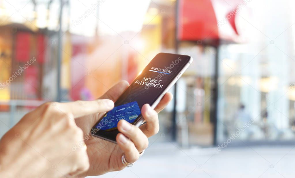 Man using mobile payments online shopping network connection on screen, Mall department store background. All on screen and credit card are designed up.