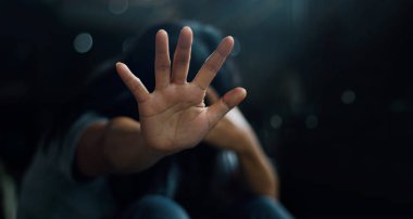 TSSB akıl sağlığı kavramı. Post travmatik stres bozukluğu. Yalnız katta oturan ve karanlık bir odada arka planda insanlardan yardım reddetmesi sallayarak depresif kadın. Film bak. Yumuşak odak.