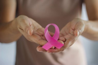 Meme kanseri bilinçlendirme kavramı. Sağlık ve Tıp. Endometriozis, tıp pembe kurdele farkındalık simgesi tutan kadın eli. Önleme meme