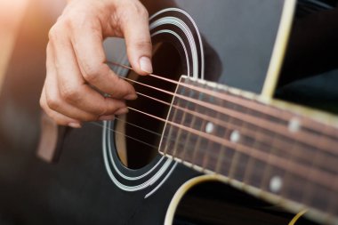 Yakın çekim. Arka plan, Erkekler ellerini akustik gitar çalmak için sahnede gitarist.