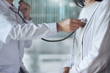  Doktor yaşlı hastanın kalp hızı için stetoskop kontrolü kullanarak