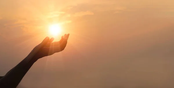 Mains de femme priant pour la bénédiction de Dieu sur fond de coucher de soleil — Photo