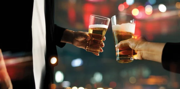 Primer plano de dos hombres beben vasos de cerveza beben bebidas alcohólicas juntos mientras están en el mostrador del bar en el pub — Foto de Stock