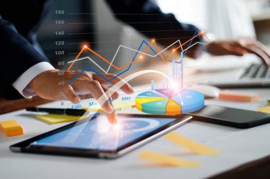 İşadamı tablet ve dizüstü bilgisayar kullanarak satış verilerini ve ekonomik büyüme grafik analizi. İş stratejisi. Dijital pazarlama