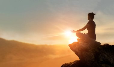 Kadın yoga ve dağ günbatımı arka plan üzerinde meditasyon