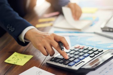 Bütçeyi hesaplamak ve satış verilerini ve büyüme grafiğini analiz etmek için hesap makinesi kullanan işadamı, Ödemeler, İş finansmanı ve muhasebe bankacılığı.