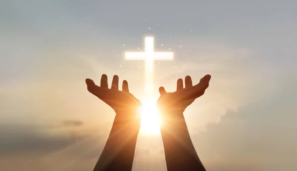 El hombre manos de la palma orando y la adoración de la cruz, la terapia eucarística bendiga a Dios ayudando, la esperanza y la fe, el concepto de religión cristiana en el fondo del atardecer . — Foto de Stock