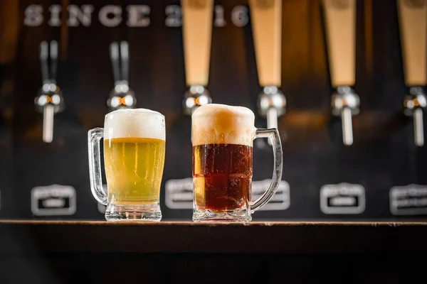 İki bardak dolusu Chopp, birinde Pilsen Chopp, diğerinde de siyah pirzola var.