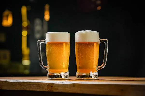 İki bardak dolusu Chopp, birinde Pilsen Chopp, diğerinde de siyah pirzola var.