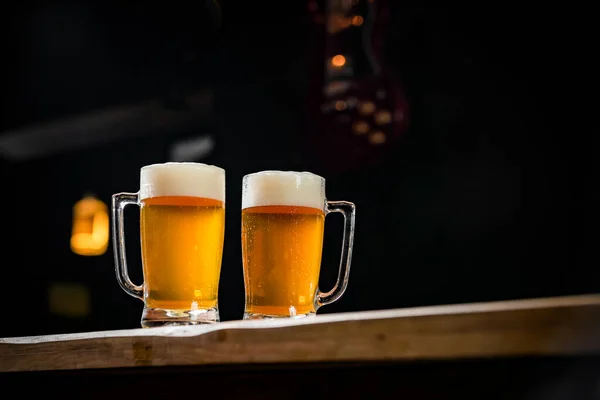 İki bardak dolusu Chopp, birinde Pilsen Chopp, diğerinde de siyah pirzola var.