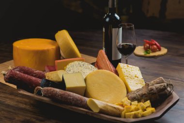 Peynirli tepsi, salam, domuz eti, şarap.