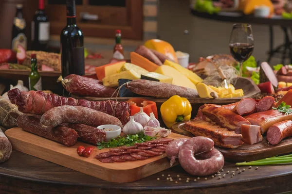 İçinde çeşitli hayvan proteini, peynir, salam ve pastırma bulunan bir masa.