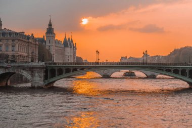 Günbatımı nehri senası Paris, arka planda tekne ve köprüler var.