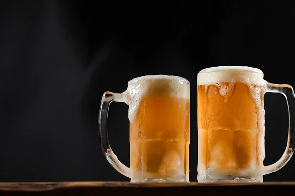 Duas Canecas Frias Com Cerveja Com Espuma Transbordante Sobre Mesa — Fotografia de Stock