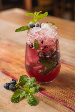 Çilekli mojito kokteyli, naneli, ahşap masa arkasında.