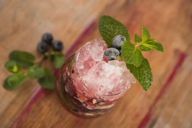 Çilekli mojito kokteyli, naneli, ahşap masa arkasında.