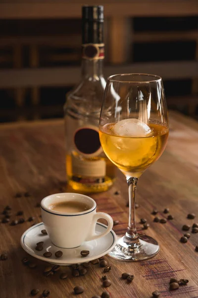 Carajillo kokteyli, İspanyol içkisi 43 'lü ve kahve, arka planda ahşap masa.
