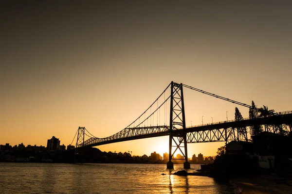 Cable, Florianopolis, Santa Catarina, Brezilya 'daki Hercilio Luz köprüsünde günbatımında renkli gökyüzü ve yapının silüetiyle kaldı.
