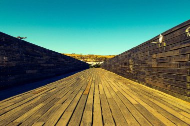 Tahta köprü ve kumsalın yanındaki mavi gökyüzü.