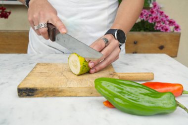 Sebze pişiren genç bir kadının elleri.