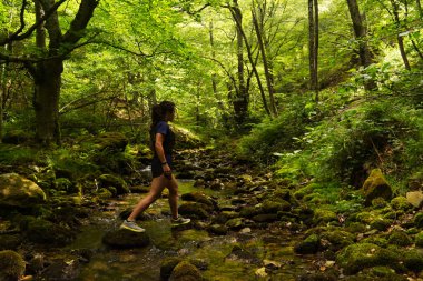 Dağlarda yürüyüş yapan genç bir kadın.