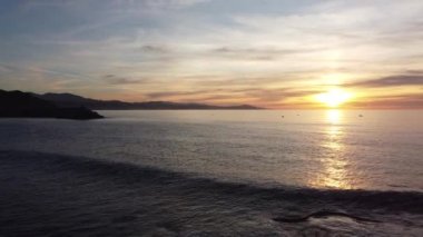 Günbatımında sörfçülerle birlikte Zumaia sahili manzarası