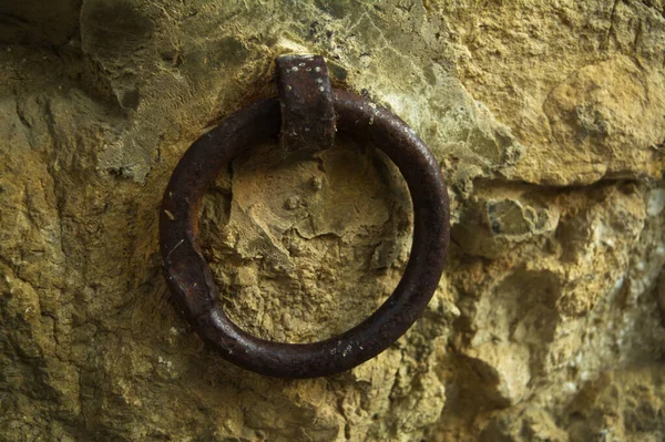 Duvardaki paslı metal kapı kolu.